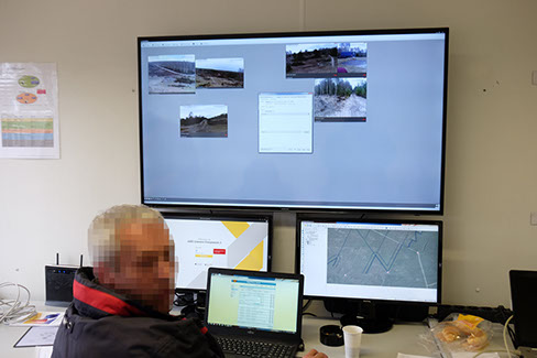 Central monitoring station in the container showing multiple camera feeds; the person pictured is pixelated